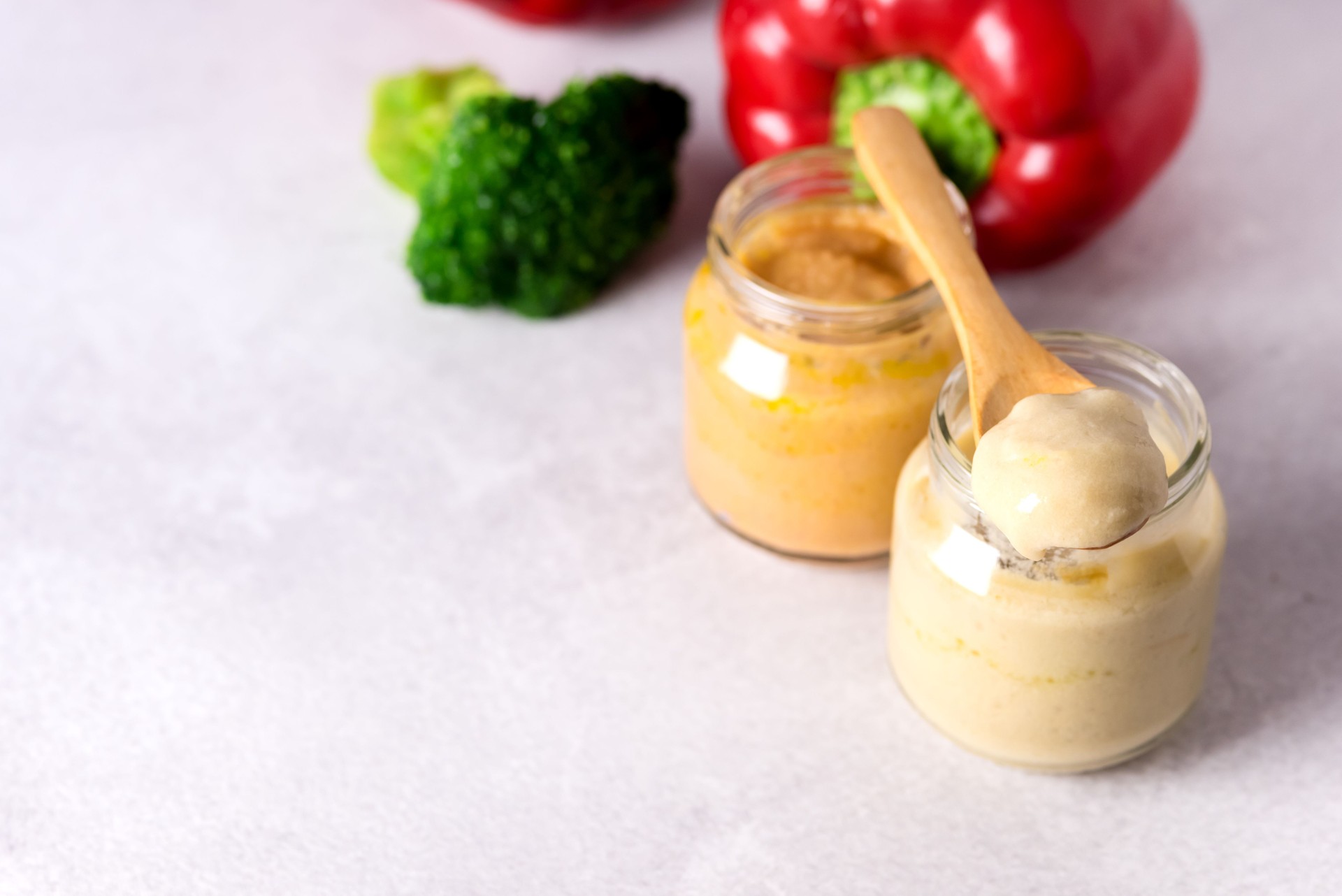 Glass Jars with Natural Baby Food on the Light Gray Background Vegetable Puree with Broccoli and Red Pepper Copy Space